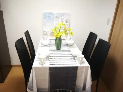 a table with a vase of yellow flowers on it at \u611b\u306e\u5c4b\u6c11\u6cca\u65b0\u5bbf in Tokyo