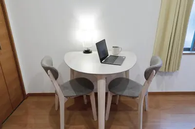 a white table with a laptop on it with two chairs at Life Town Shinkoiwa - Akihabara Direct Access - 7mins walk from sta in Tokyo