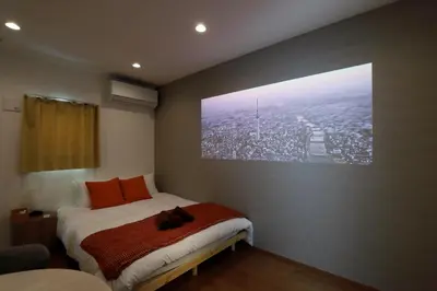 a bedroom with a bed with a picture of a city at Life Town Shinkoiwa - Akihabara Direct Access - 7mins walk from sta in Tokyo