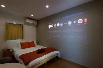 a room with a bed with a large screen on the wall at Life Town Shinkoiwa - Akihabara Direct Access - 7mins walk from sta in Tokyo