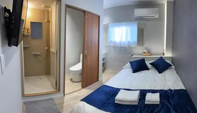 a bedroom with a blue and white bed and a shower at \u6d45\u8349\u99c5\u5f92\u6b698\u5206 \u6d45\u8349\u5bfa\u3059\u3050\u305d\u3070\u306e\u4ef2\u898b\u4e16\u6563\u7b56\u30b9\u30c6\u30a4 DqcYoE in Tokyo