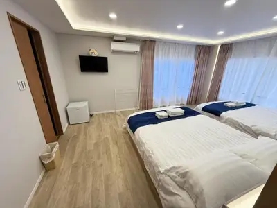 a hotel room with two beds and a flat screen tv at \u6d45\u8349\u99c5\u5f92\u6b698\u5206 \u6d45\u8349\u5bfa\u3059\u3050\u305d\u3070\u306e\u4ef2\u898b\u4e16\u6563\u7b56\u30b9\u30c6\u30a4 DqcEoY in Tokyo
