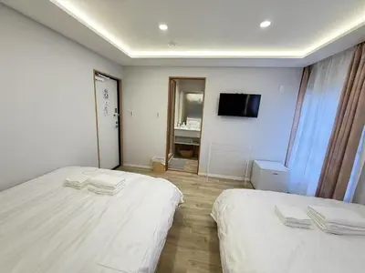 a hotel room with two beds and a television at \u6d45\u8349\u99c5\u5f92\u6b698\u5206 \u6d45\u8349\u5bfa\u3059\u3050\u305d\u3070\u306e\u4ef2\u898b\u4e16\u6563\u7b56\u30b9\u30c6\u30a4 DqcEoE in Tokyo