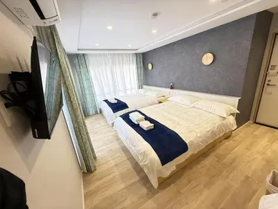 a bedroom with a large bed with blue sheets at \u6d45\u8349\u99c5\u5f92\u6b698\u5206 \u6d45\u8349\u5bfa\u3059\u3050\u305d\u3070\u306e\u4ef2\u898b\u4e16\u6563\u7b56\u30b9\u30c6\u30a4 DqcSoY in Tokyo