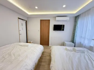 a bedroom with two beds and a flat screen tv at \u6d45\u8349\u99c5\u5f92\u6b698\u5206 \u6d45\u8349\u5bfa\u3059\u3050\u305d\u3070\u306e\u4ef2\u898b\u4e16\u6563\u7b56\u30b9\u30c6\u30a4 DqcSoE in Tokyo