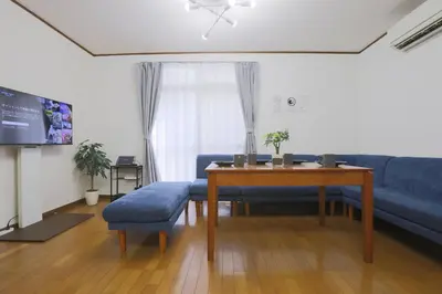 a living room with a blue couch and a table at Omorinishi 3chome House in Tokyo