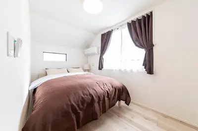 a bedroom with a bed and a window at Akabanenishi 3chome House in Tokyo