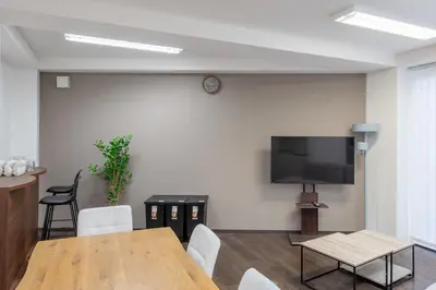 a room with a table and a tv on a wall at Tomihisa House in Tokyo