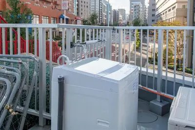 a washing machine on a balcony with a city at Tomihisa House in Tokyo