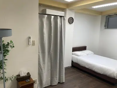 a bedroom with a bed and a shower curtain at Tomihisa House in Tokyo