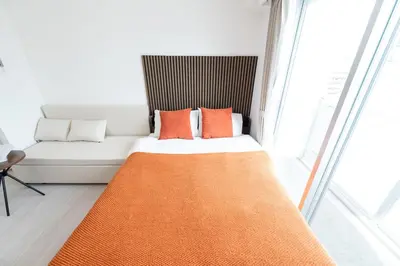 a white couch with orange pillows in a room at LIVCITY Kinshicho 1101 Skytree view in Tokyo