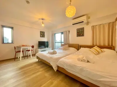 a bedroom with two beds and a desk and a table at YMK Oshiage 7B in Tokyo