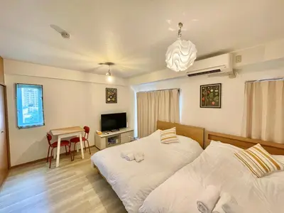 a bedroom with two beds and a table and a television at YMK Oshiage 7B in Tokyo