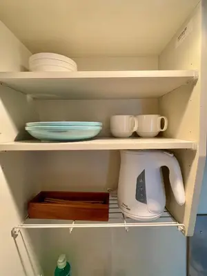 a kitchen shelf with bowls and plates and a mixer at YMK Oshiage 7B in Tokyo
