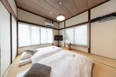 a bedroom with two beds in a room with windows at \u3077\u3075\u304b\u767d\u9b1a in Tokyo