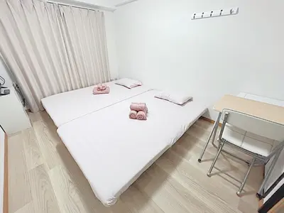 two beds in a room with a table and a chair at Tokyo Stay West Sugamo #102 in Tokyo