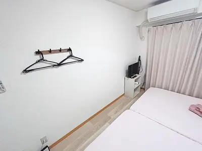 a white room with two beds and a tv at Tokyo Stay West Sugamo #102 in Tokyo