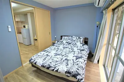 a bedroom with a bed with a black and white comforter at MW Hotel in Tokyo
