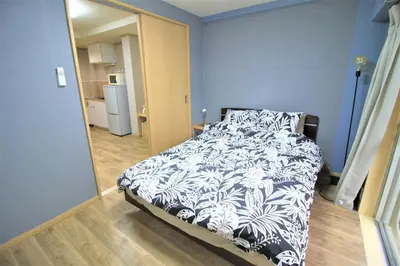 a bedroom with a bed with a black and white comforter at MW Hotel in Tokyo