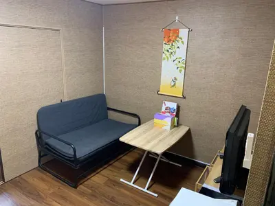 a waiting room with a blue chair and a table at MW Hotel in Tokyo