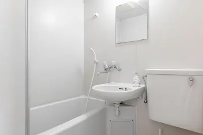 a white bathroom with a sink and a shower at \u30a2\u30b9\u30d4\u30a2502 7-minute walk from Nishi-Sugamo Station 9-minute walk from Sugamo Station 1-minute walk from Koshinzuka WiFi available in Tokyo