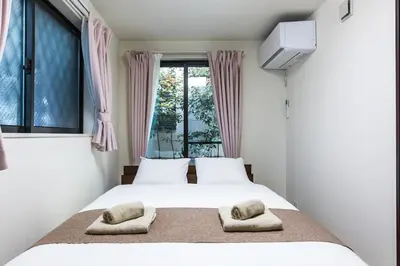 a bedroom with a bed with two pillows and a window at \u304b\u307e\u3082\u30551 in Tokyo