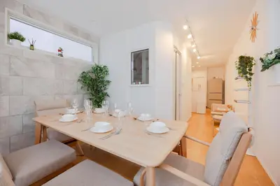 a white dining room with a table and chairs at First Choice Minami Kamata in Tokyo
