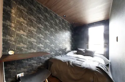 a bedroom with a bed and a wall with a window at S-rea TOKYO in Tokyo