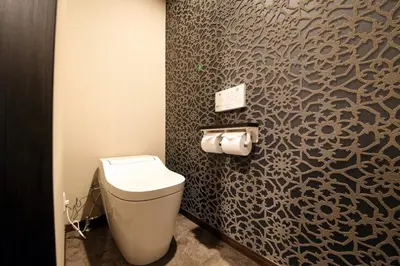 a bathroom with a toilet and a wall at S-rea TOKYO in Tokyo