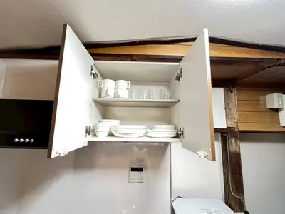 a kitchen with white cabinets and plates in it at Akabane Nishi kodate AN1 in Wada