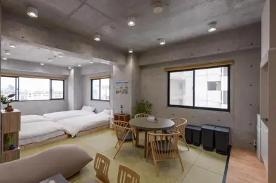 a room with a bed and a table and chairs at \u539f\u7530\u5c4b Hotel 7F in Tokyo