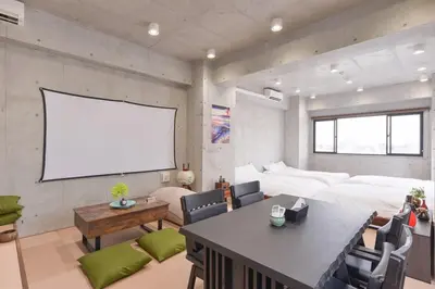a living room with a white screen in a room at \u539f\u7530\u5c4b Hotel8F in Tokyo