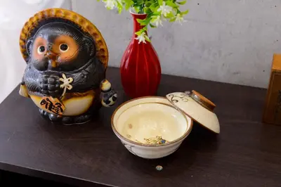 a wooden table with a bowl and a vase at \u539f\u7530\u5c4b Hotel8F in Tokyo