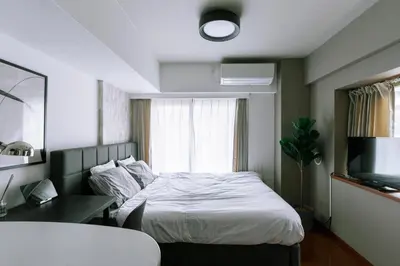 a bedroom with a bed and a desk and a television at Kabukicho Queen Bed Hotel in Tokyo