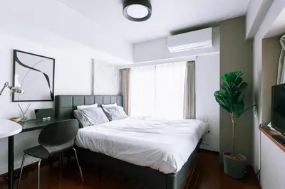 a bedroom with a bed and a desk and a window at Kabukicho Queen Bed Hotel in Tokyo