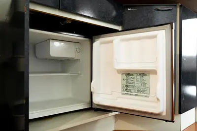 an empty refrigerator with its door open in a kitchen at Kabukicho Queen Bed Hotel in Tokyo