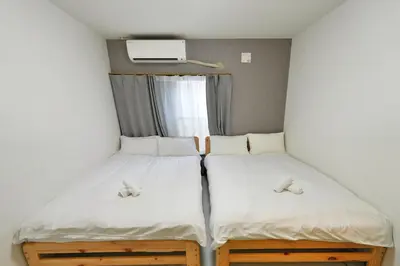 two beds in a small room with a window at miraisya shinkoiwa in Tokyo