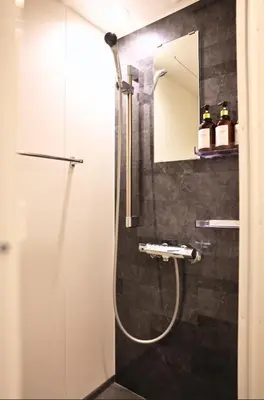 a bathroom with a shower with a sink and a mirror at Miu Hotel Togoshi Ginza - Festival Vibes Every Day with Easy Access to Landmarks, Bullet Train & Airports in Tokyo