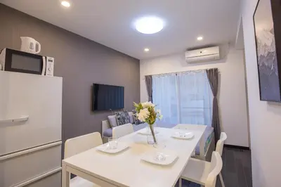 a dining room with a white table with flowers on it at \u5927\u4e45\u4fdd\u30b3\u30ea\u30a2\u30f3\u30bf\u30a6\u30f3\u76f4\u901a \u5317\u65b0\u5bbf\u306e\u30e2\u30c0\u30f3\u30b2\u30b9\u30c8\u30cf\u30a6\u30b9 YoYi in Tokyo