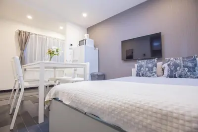 a bedroom with a bed and a desk and a tv at \u5927\u4e45\u4fdd\u30b3\u30ea\u30a2\u30f3\u30bf\u30a6\u30f3\u76f4\u901a \u5317\u65b0\u5bbf\u306e\u30e2\u30c0\u30f3\u30b2\u30b9\u30c8\u30cf\u30a6\u30b9 YoYi in Tokyo
