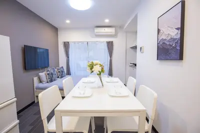 a dining room with a white table and chairs at \u5927\u4e45\u4fdd\u30b3\u30ea\u30a2\u30f3\u30bf\u30a6\u30f3\u76f4\u901a \u5317\u65b0\u5bbf\u306e\u30e2\u30c0\u30f3\u30b2\u30b9\u30c8\u30cf\u30a6\u30b9 YoYi in Tokyo