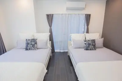 two beds in a small room with a window at \u5927\u4e45\u4fdd\u30b3\u30ea\u30a2\u30f3\u30bf\u30a6\u30f3\u76f4\u901a \u5317\u65b0\u5bbf\u306e\u30e2\u30c0\u30f3\u30b2\u30b9\u30c8\u30cf\u30a6\u30b9 YoYi in Tokyo