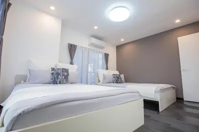 a bedroom with two beds and a window at \u5927\u4e45\u4fdd\u30b3\u30ea\u30a2\u30f3\u30bf\u30a6\u30f3\u76f4\u901a \u5317\u65b0\u5bbf\u306e\u30e2\u30c0\u30f3\u30b2\u30b9\u30c8\u30cf\u30a6\u30b9 YoYi in Tokyo