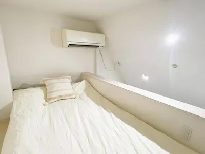a white bed in a room with a heater at Green house Japan in Tokyo