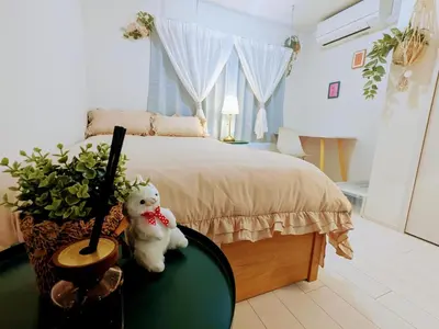 a white teddy bear sitting on a table next to a bed at The Tokyo Okubo Shinjuku Homestay in Tokyo