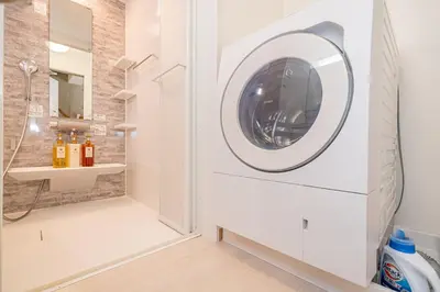 a washing machine in a bathroom with a mirror at Kei House Shin-Okubo in Tokyo
