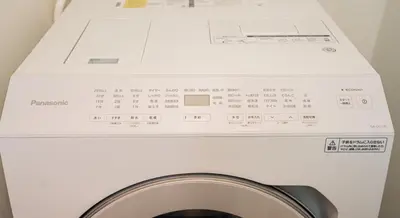 a washing machine with a box on top of it at Kei House Shin-Okubo in Tokyo
