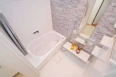 a white bathroom with a tub and a sink at Kei House Shin-Okubo in Tokyo