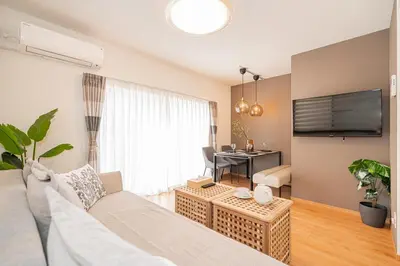 a living room with a white couch and a table at Kei House Shin-Okubo in Tokyo
