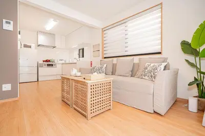a living room with a couch and a table at Kei House Shin-Okubo in Tokyo